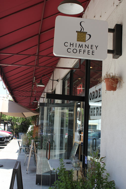 The Chimney Coffee blade sign above the sidewalk in Chinatown